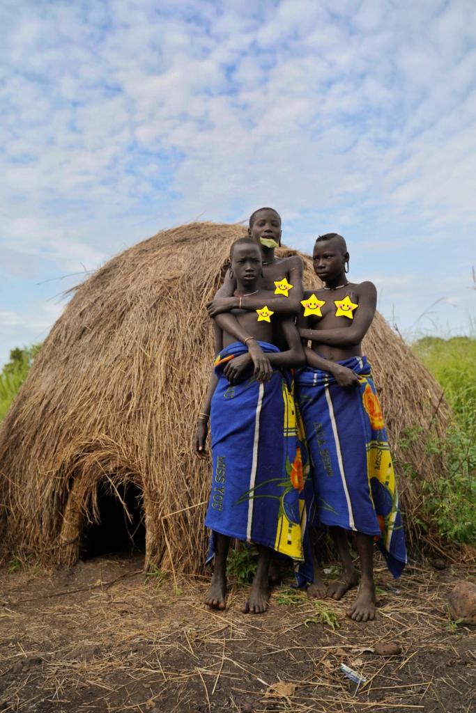 Mursi young ladies with their hut
